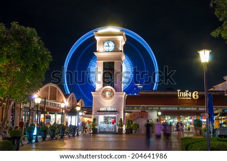 BANGKOK, THAILAND - JULY 10 : The clock tower with ferris wheel and warehouse background at the asiatique river front on July 10, 2014 Bangkok, Thailand