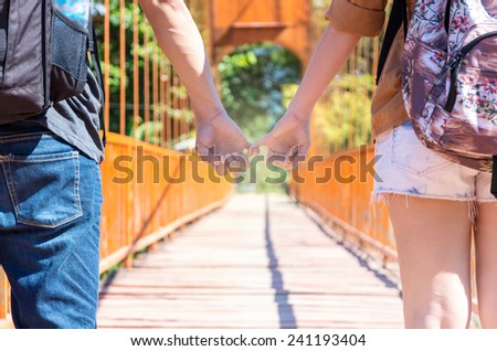 couple of traveler holding hands on the wooden bridge