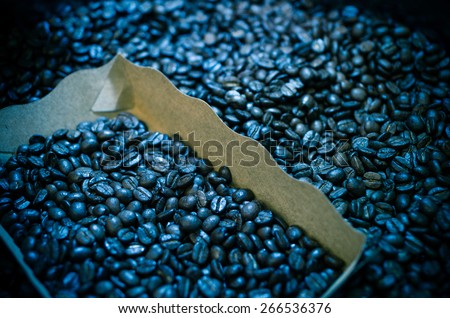 roasted coffee beans in the box, focus some part of all, dark blue tone