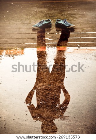 The man reflection in the water after raining