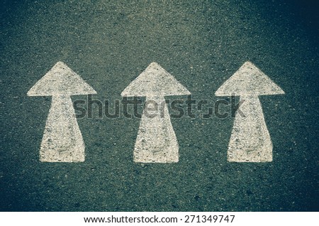 asphalt road with drawn direction arrow