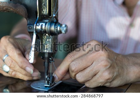 Closeup Sewing Process with old man designer hand