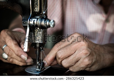 Closeup Sewing Process with old man designer hand, vintage color tone