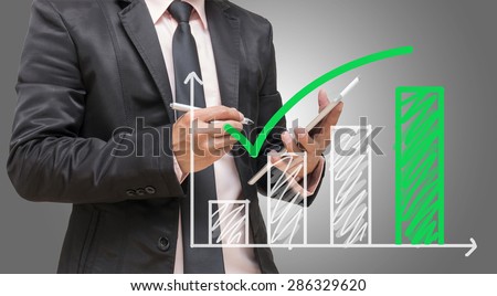 Businessman hand writing a graph on gray background, Business investment concept
