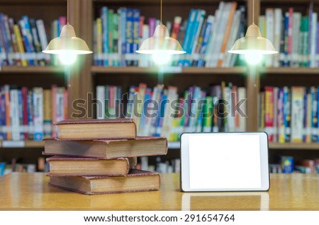 old book on the desk in library with tablet and Luxury lighting decoration