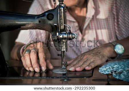 Sewing Process by the vintage sewing machine on old man designer blur background, vintage color tone