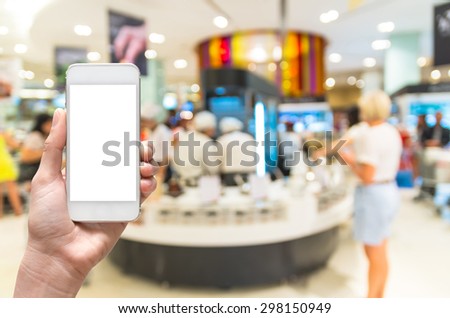 Female hand holding mobile smart phone on salad bar store blur background, business concept