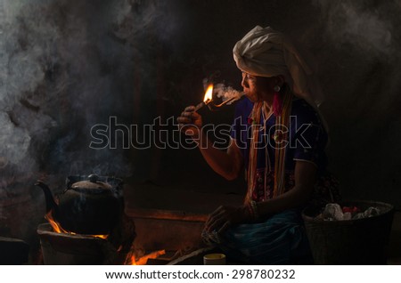 Portrait of Old wrinkled Asian woman smoking traditional tobacco in countryside at doi inthanon,chiang mai, Thailand, soft focus on face, dark black tone