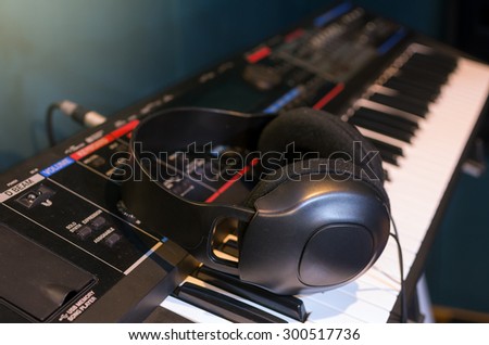Close up of headphone on keyboard in music studio room, music instrument concept