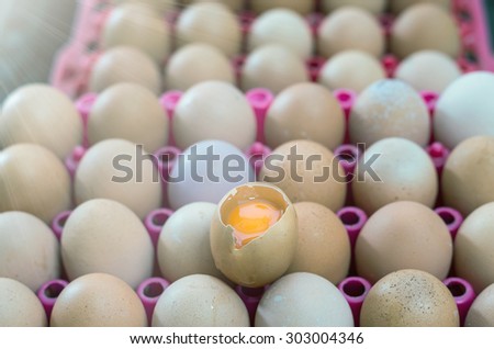 one egg is opened on stack of eggs