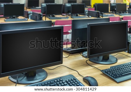 Many rows of computer in Computer Lab, focus on first LCD monitor