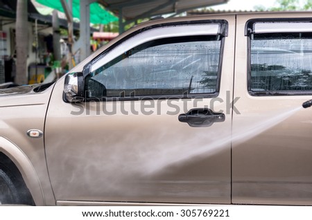 Car wash by high pressure cleaners, focus on the car