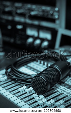 Close up of microphone with equipment on mixer in music studio, music instrument concept