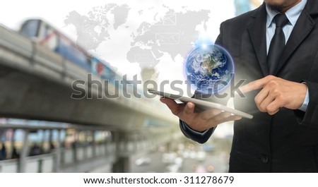 Businessman using the smart phone with earth and world map on abstract Blurred photo of traffic jam with rush hour, Elements of this image furnished by NASA