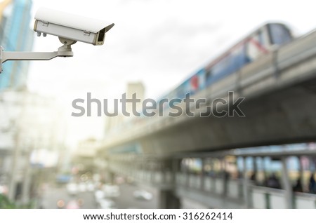 CCTV security camera on the abstract Blurred photo of sky train with traffic jam