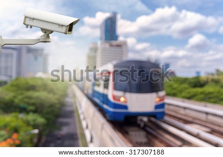 CCTV security camera on the abstract Blurred photo of sky train with traffic and cityscape