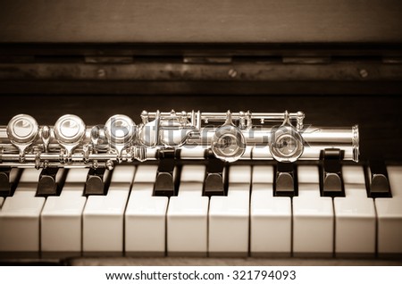 Closeup Flute on the keyboard of piano, musical instrument, vintage tone