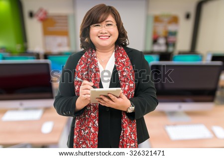 Professor Senior woman using the tablet on the Abstract blurred photo of empty server room, education and business concept