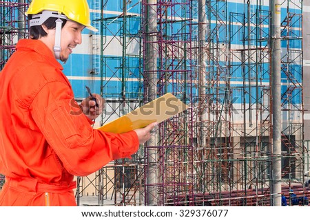 Happy Asian engineers writing the note pad on construction site workers, industrial construction concept
