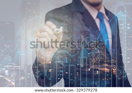 Double exposure of businessman with Trading graph on the cityscape background,Business financial concept