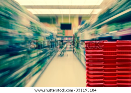 Abstract blurred photo of store with red color basket in department store bokeh background