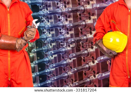 Engineers worker holding the tools on Industrial equipment of PET preforms background, industry concept