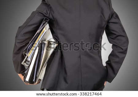 Businessman is holding many document folders, back side, business busy concept, include clipping path