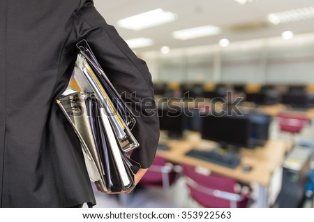 Businessman is holding many document folders on Abstract blurred photo of empty server room, back side, business busy concept