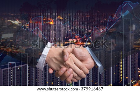 Hand shake between businessman on Trading graph on the cityscape at night and world map background,Business financial concept