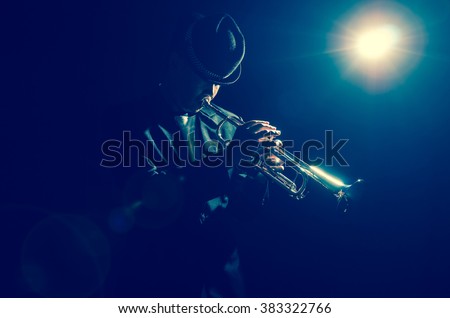 Musician playing the Trumpet with spot light and len flare on the stage