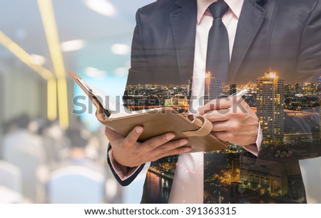 Double exposure of Businessman writing the note book on the Abstract blurred photo of conference hall or seminar room with attendee background