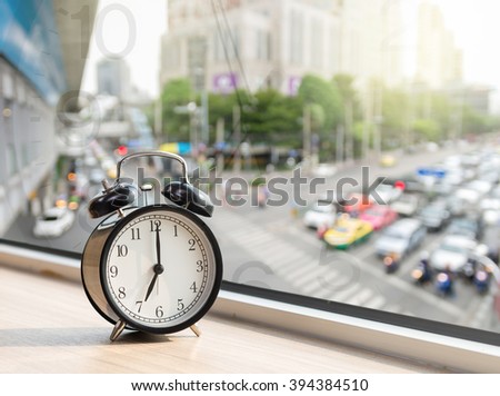 Vintage alarm clock at windows with abstract Blurred photo of traffic jam with rush hour on early morning, traffic transportation concept