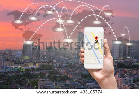 female hands holding a smart phone showing part of navigator map over screen on connection line over the world map with cityscape, Navigation concept,Elements of this image furnished by NASA