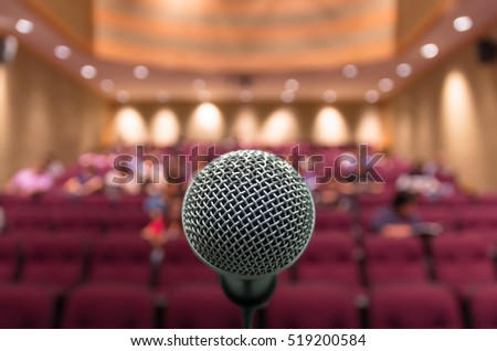 Microphone with Abstract blurred photo of conference hall or meeting room with attendee background