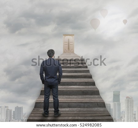 Businessman standing for walking up stairs to the door over the cloud and sky and balloon with sun over the cityscape background,Success business and Ambitions concept