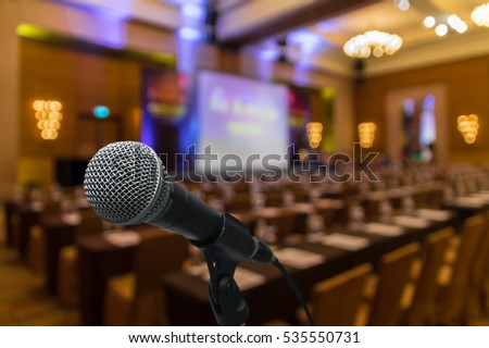 Microphone over the Abstract blurred photo of conference hall or seminar room with attendee background, business and education concept