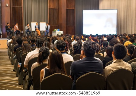 Speakers on the stage with Rear view of Audience in the conference hall or seminar meeting, business and education concept