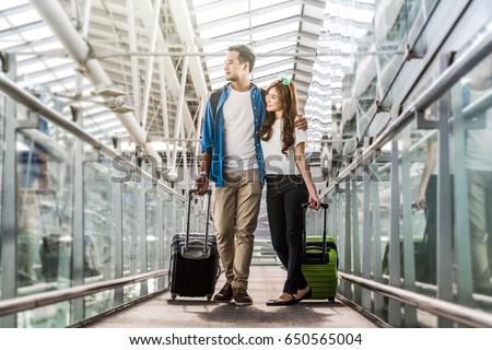 Asian couple traveler with suitcases at the airport. Lover travel and transportation with technology concept