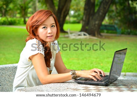 Beautiful woman with laptop in the garden