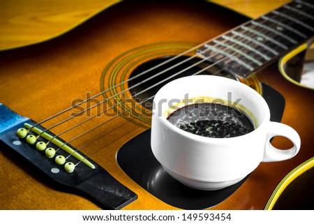 Acoustic guitar with a cup of coffee