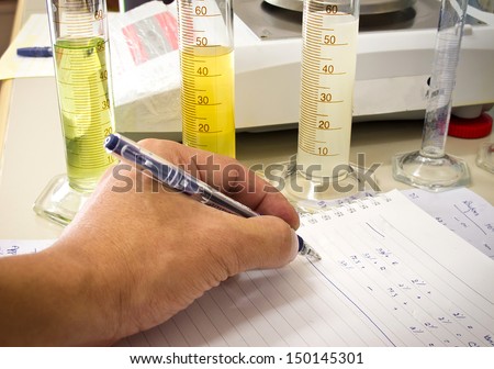 Graduated cylinder in laboratory with hand of someone