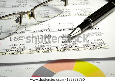 Finance balance report with black pen and glasses