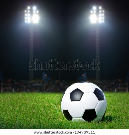 Soccer ball on the field with sport light in stadium at night