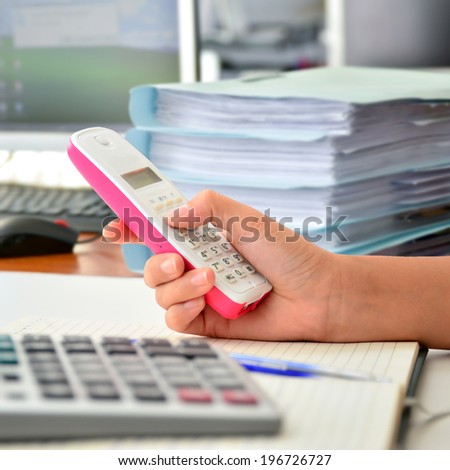 Telephone in woman hand at office