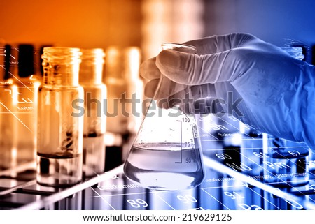 flask in scientist hand with laboratory glassware