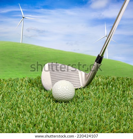Golf ball and golf club with wind turbine on hill background