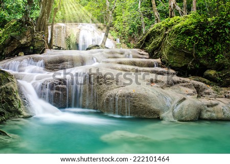 Beautiful waterfall with sunshine in tropical forest, Erawan waterfall, Thailand