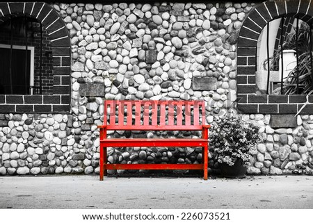 Red chair with stone wall