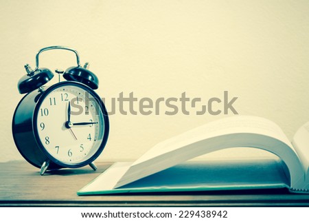 Retro Alarm clock on text books, vintage green tone