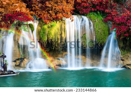Beautiful waterfall with rainbow in autumn forest